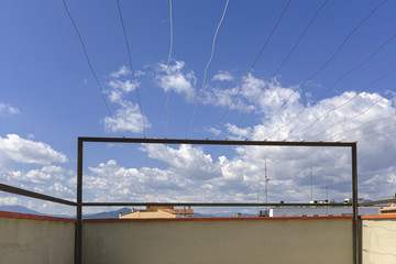 Sunny blue sky with some clouds on a clothesline on a roof building with nobody on it