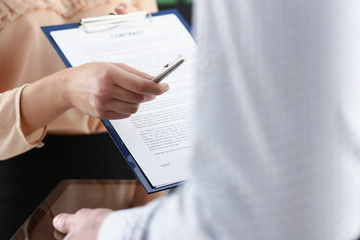 Smiling woman offer contract form on clipboard pad and silver pen to sign closeup. Strike a bargain for profit white collar motivation union decision corporate sale insurance agent concept
