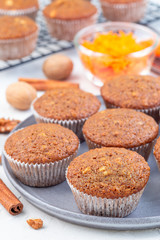 Homemade carrot cake muffins with walnuts on gray plate, vertical