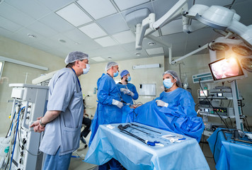 Neurourgeons are operating with medical robotic surgery machine. Modern automated medical device. Surgical room in hospital with robotic technology equipment, machine arm neurosurgeon.