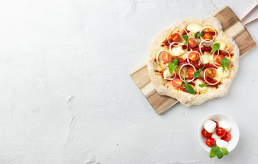 Vegetarian pizza with vegetables on Roman pastry with onions, tomatoes, mozzarella and arugula....