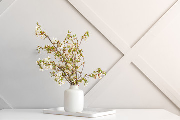 Fototapeta na wymiar Vase with beautiful blooming branches on table