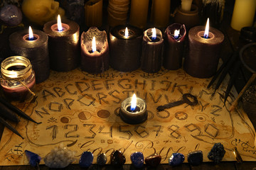 Talking spiritual board with black candles and old key.