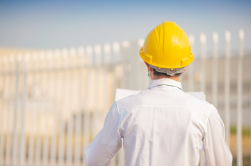 Businessman use surgical mask yellow hard hat holding blueprint inspection construction building estate