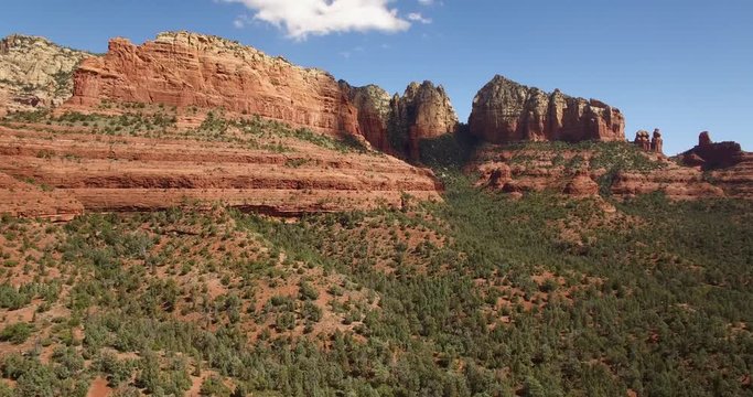 Aerial ascent from forests to red rock formations Sedona, Arizona