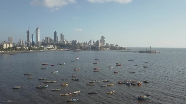 An aerial track in view of Haji Ali Dargah and the arabian sea with fisher boats in the foreground