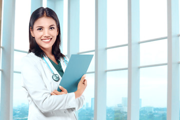 Fototapeta na wymiar Asian doctor woman with stethoscope holding a clipboard