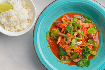 Mixed vegetable seafood salad and a bowl of rice with a piece of lime. Asian cuisine.