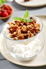 Chia pudding with thai mango and caramelized granola in glass bowl