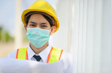 Engineer construction holding blueprint working on site