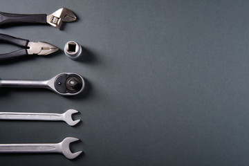 Steel wrenches, pliers, on a dark background, a place for an inscription