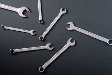 Steel wrenches on a dark background, top view
