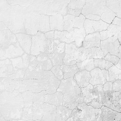 the background of the cracked white wall of the house is old covered with plaster and the paint is peeling from time. Very old house. cracks in the wall
