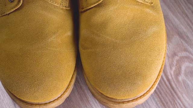 male hand rubs spot on shoes made of nubuck or suede