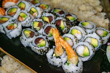 a varied selection of freshly made california sushi rolls presented on a skateboard 