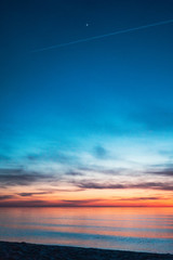 colorful sunset by the sea with a first star visible