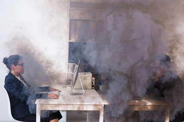 Close-up of fire burning inside the office cabin during works. Men and women office workers in a...