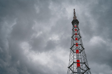 Urban style, dark sky, TV station TV tower on a cloudy sky background