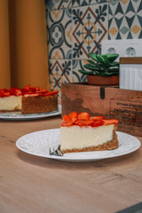 Homemade cheesecake with fresh strawberries photographed in a beautiful wooden kitchen