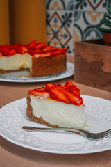 Homemade cheesecake with fresh strawberries photographed in a beautiful wooden kitchen