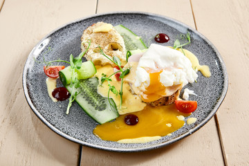 Eggs Benedict with ham and toasts side view