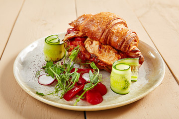 Croissant with grilled pepper and turkey meat close up
