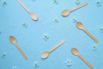 Eco-friendly disposable kitchenware and apple flowers on a blue background. The concept of zero...