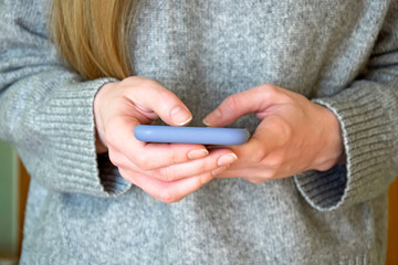 Smartphone in hands of young girl. She browses information on mobile phone screen. Mobile...