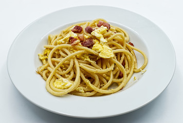 Homemade traditional Italian Spaghetti alla carbonara with egg yolk isolated on white