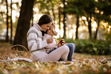 Mother and daughter enjoying autumn in park.