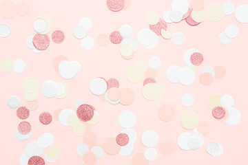 Multicolor pink, gold and white confetti on the light peach pink background, holiday celebration backdrop, Flat lay style with place for text