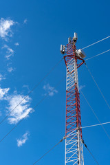 Phone tower antenna with blue sky and cloud background