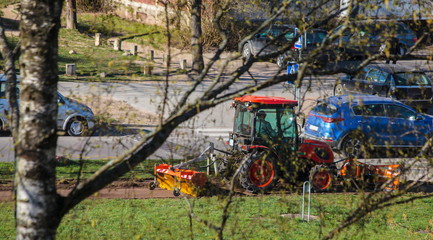 The tractor cleanes the sidewalk