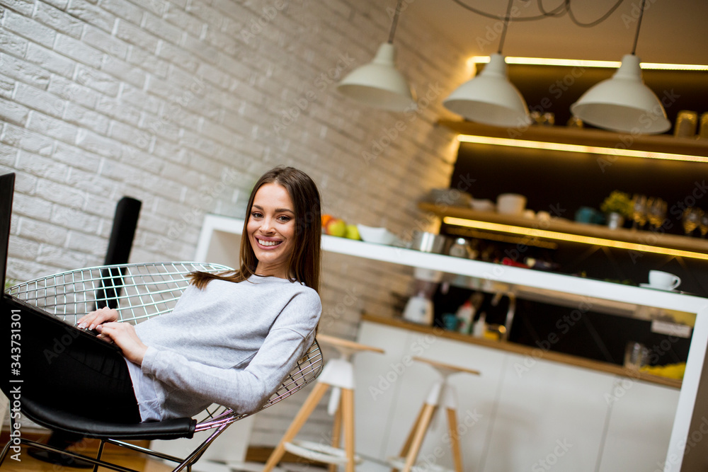 Poster Beautiful young asian woman with happy smile relaxing while sitting on  chair in living room