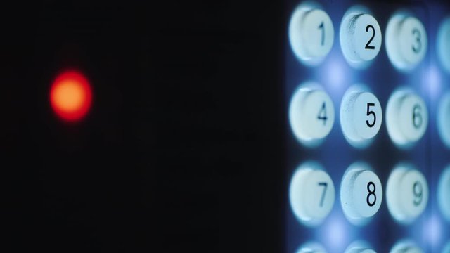 A person enters a pin code on a backlit keyboard