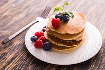 Close-up delicious pancakes with fresh blueberries and raspberries.