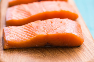 Fresh raw salmon on wooden cutting board.