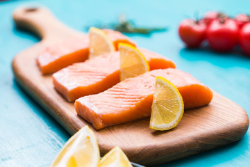 Delicious salmon steak on wooden cutting board, close-up.