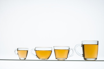 glass teapot and cups with hot tea on table, close view    