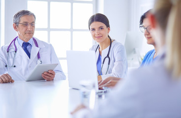 Serious medical team discussing patient's case in a bright office