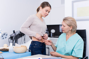Cosmetologist examining girl body