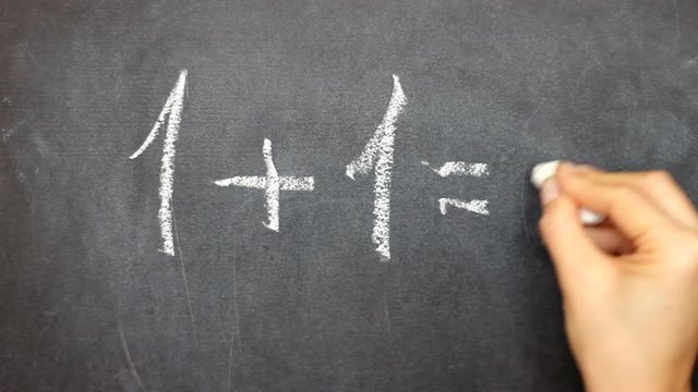 Hand writing with chalk on chalkboard mathematical equation, one plus one equals two