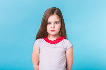 Beautiful little girl isolated on a blue background. Childhood and children concept.