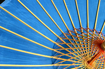 Beautiful sky blue background - vietnamese traditional  umbrella  with radial wooden ribs, close up photo, asian handicraft, diagonal composition