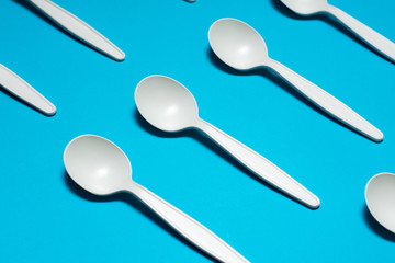 disposable spoons of corn starch on a blue background. biodegradable  tableware. environmentally friendly, isolate. plastic replacement. modern biomaterials