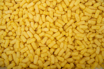 Yellow corn sticks close-up. Background of corn sticks. Harmful sweet food. Diabetes.