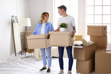 Couple holding boxes for moving the hands and looking inside box