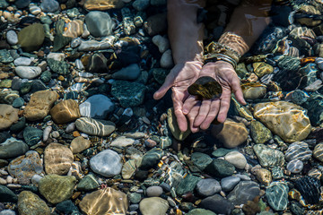 female hands holding pebbles