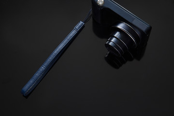 Obraz premium Dark blue camera on a black background, there is space for text. The concept of black minimalism.