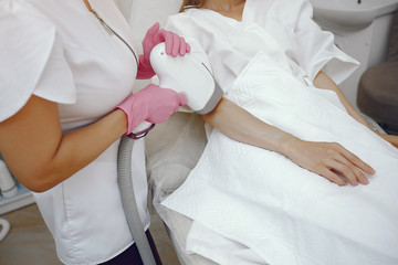 Cosmetologist use laser. Woman with cosmetologist. Lady in a beauty studio.